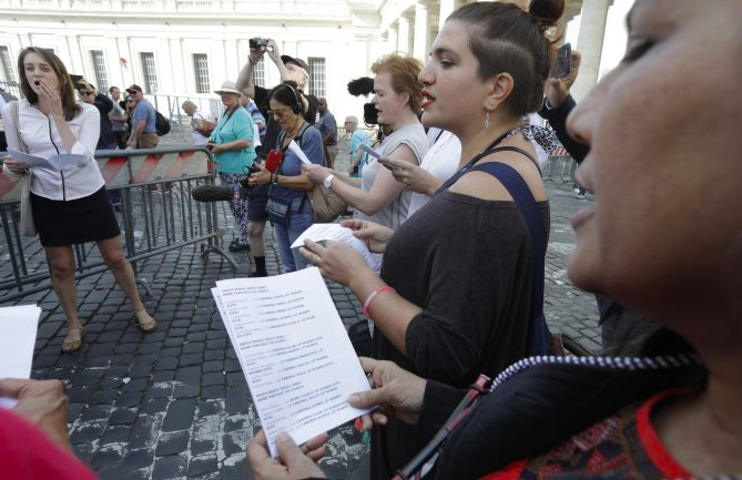 Mujeres de pie y cantando juntas en una calle de Roma, cerca del Vaticano. 